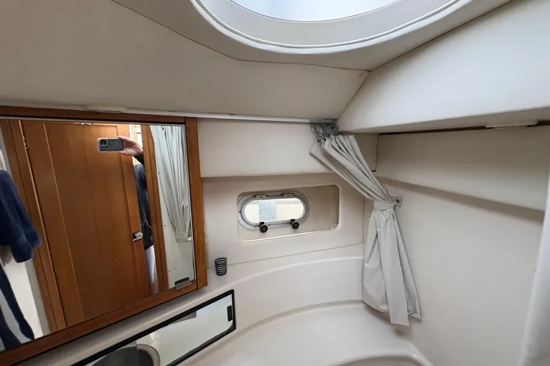 Slide: The Image of 1988 Bayliner 3587 Motoryacht bathroom with mirror, porthole, and white curtain. - 74