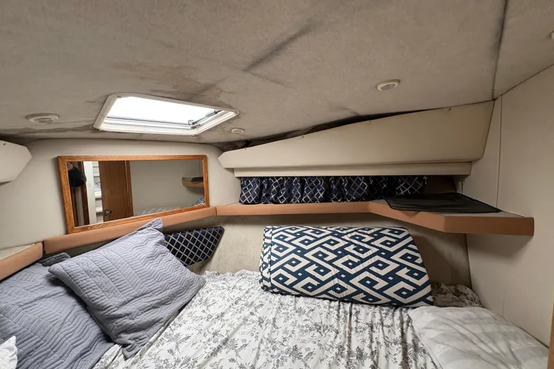 Slide: The Image of Cozy cabin interior of 1988 Bayliner 3587 Motoryacht with patterned bedding and skylight. - 78
