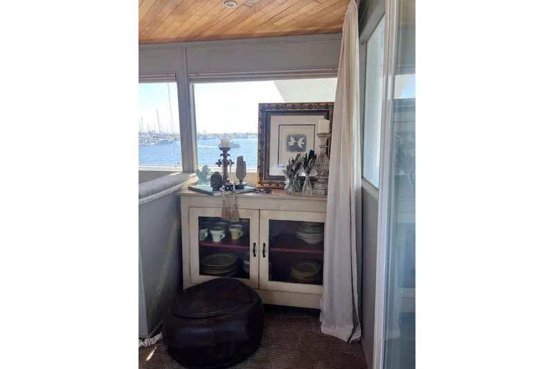 Slide: The Image of Interior of 1977 Huckins Motor Yacht with decorative cabinet and sea view. - 12