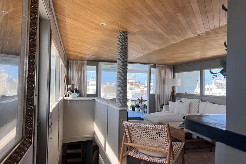 Slide: The Image of Interior of a 1977 Huckins Motor Yacht with modern decor and large windows. - 13