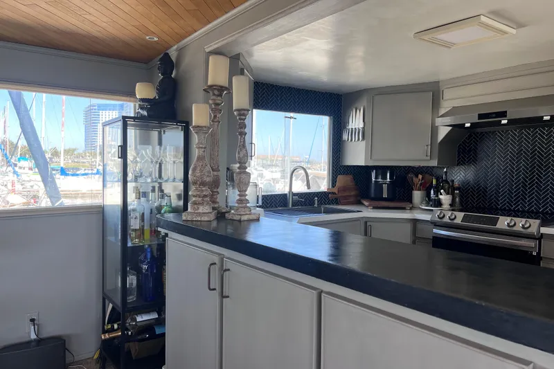 Slide: The Image of Luxurious 1977 Huckins Motor Yacht kitchen with modern appliances and marina view. - 14