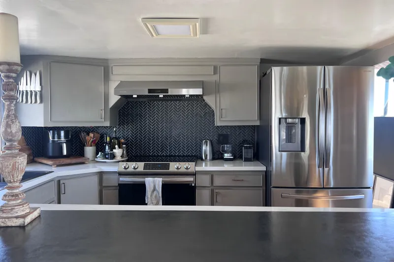 Slide: The Image of Modern kitchen on 1977 Huckins Motor Yacht with stainless steel appliances and herringbone backsplash. - 15