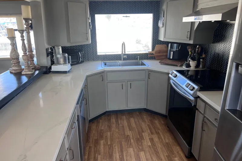 Slide: The Image of Modern kitchen interior on a 1977 Huckins Motor Yacht with sleek countertops and appliances. - 16