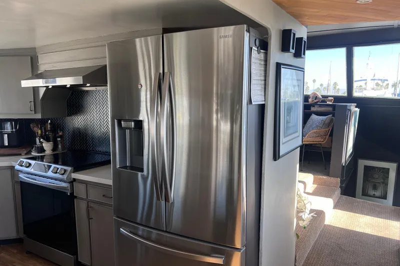 Slide: The Image of 1977 Huckins Motor Yacht interior with modern kitchen appliances and cozy seating area. - 18