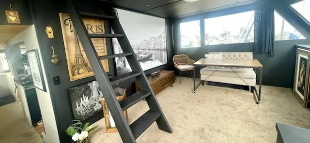 Slide: The Image of 1977 Huckins Motor Yacht interior with modern decor, ladder, and Paris-themed artwork. - 21