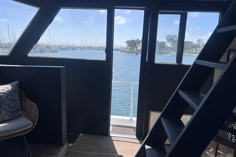 Slide: The Image of Interior view of a 1977 Huckins Motor Yacht overlooking a marina through large windows. - 25