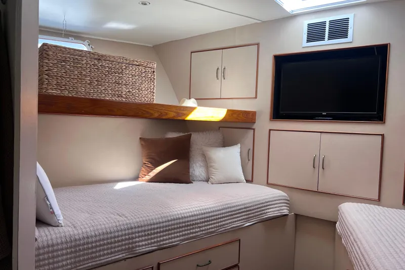 Slide: The Image of Cozy cabin interior of a 1977 Huckins Motor Yacht with TV and storage cabinets. - 27
