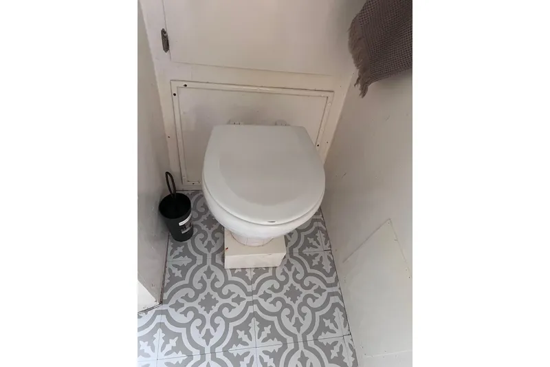 Slide: The Image of 1977 Huckins Motor Yacht bathroom with patterned floor tiles and white toilet. - 33