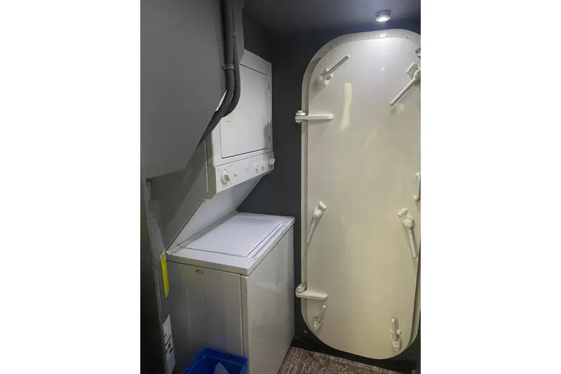 Slide: The Image of Laundry area inside 1977 Huckins Motor Yacht with stacked washer and dryer. - 35