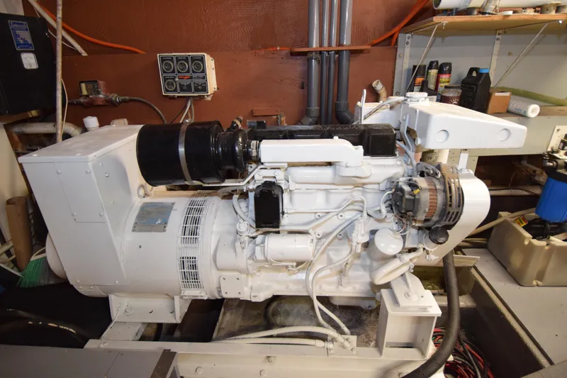 Slide: The Image of 1977 Huckins Motor Yacht engine room with generator and mechanical components. - 38
