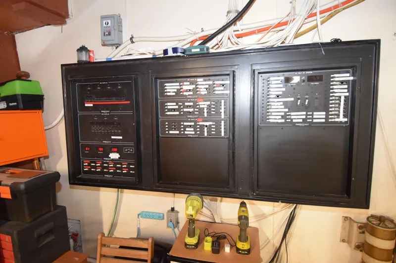 Slide: The Image of Electrical control panel on a 1977 Huckins Motor Yacht, surrounded by tools and wiring. - 39