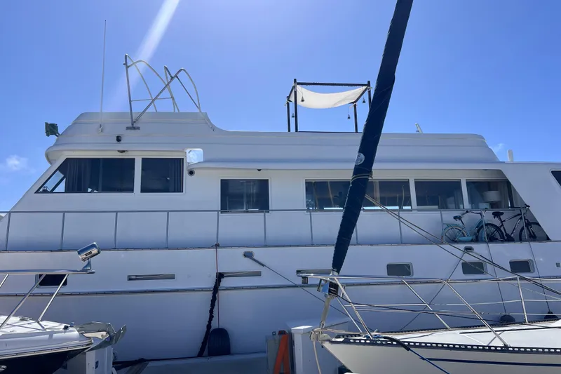 Slide: The Image of 1977 Huckins Motor Yacht docked under clear blue sky. - 4