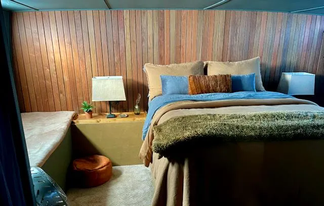 Slide: The Image of Cozy bedroom in 1977 Huckins Motor Yacht with wood paneling and plush bedding. - 40