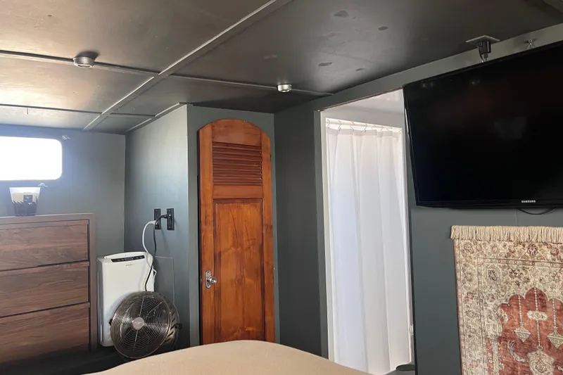 Slide: The Image of 1977 Huckins Motor Yacht interior with wooden door, TV, and modern furnishings. - 44