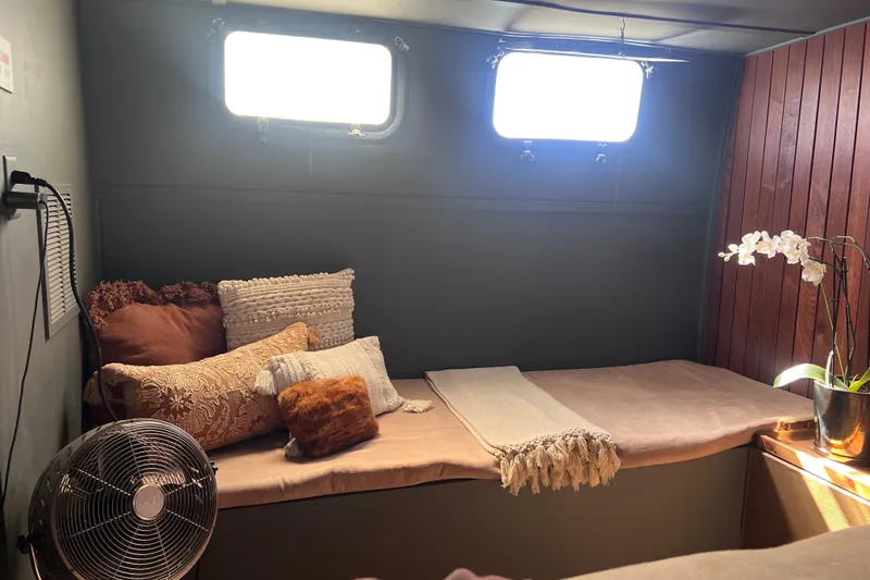 Slide: The Image of Cozy 1977 Huckins Motor Yacht interior with cushions, fan, and potted orchid. - 45