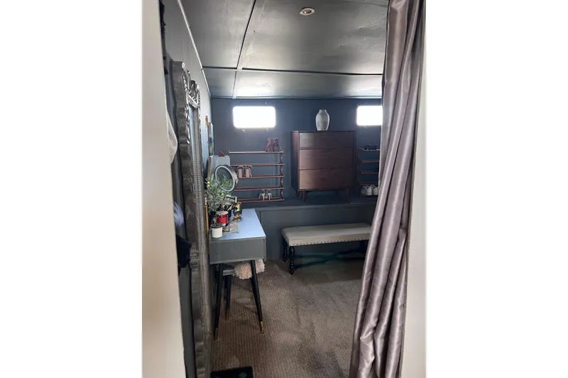 Slide: The Image of 1977 Huckins Motor Yacht interior with elegant decor, vanity, and storage shelves. - 53