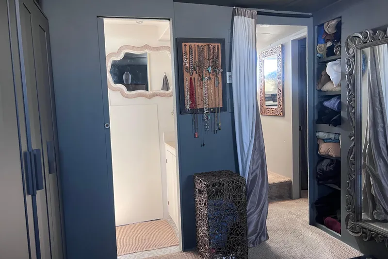 Slide: The Image of 1977 Huckins Motor Yacht interior with elegant decor, mirrors, and organized storage. - 54