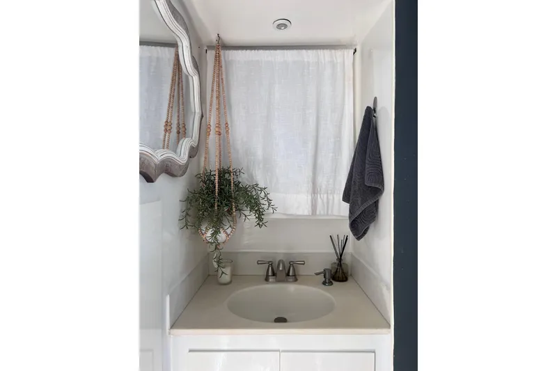 Slide: The Image of Small bathroom sink area on 1977 Huckins Motor Yacht with hanging plant and towel. - 58