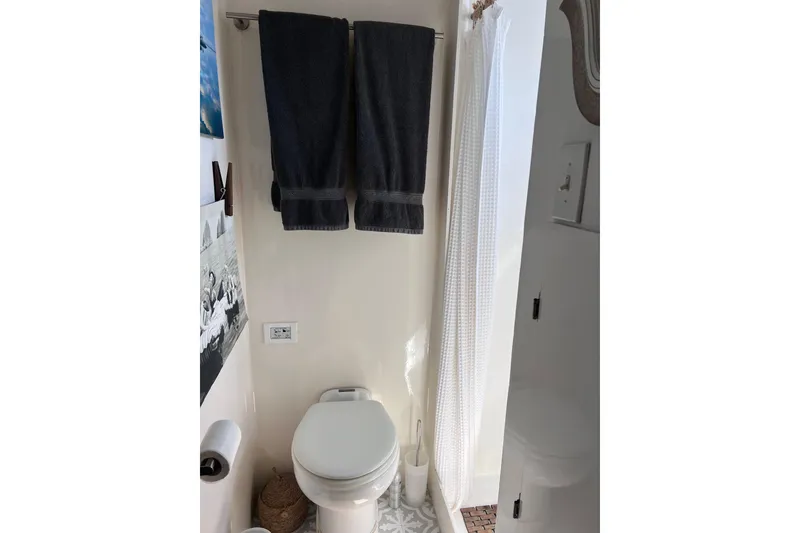 Slide: The Image of Bathroom interior of a 1977 Huckins Motor Yacht with towels and shower curtain. - 59