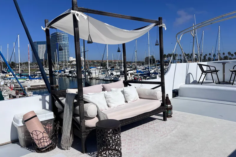 Slide: The Image of Luxurious 1977 Huckins Motor Yacht deck with elegant seating and marina view. - 61