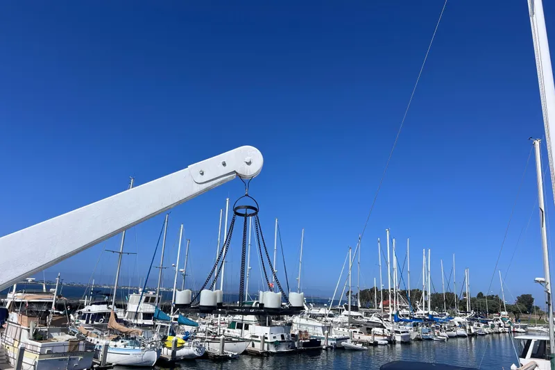 Slide: The Image of Marina with sailboats and a 1977 Huckins Motor Yacht under a clear blue sky. - 66