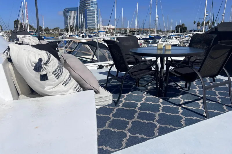 Slide: The Image of 1977 Huckins Motor Yacht deck with seating, table, and marina view. - 67