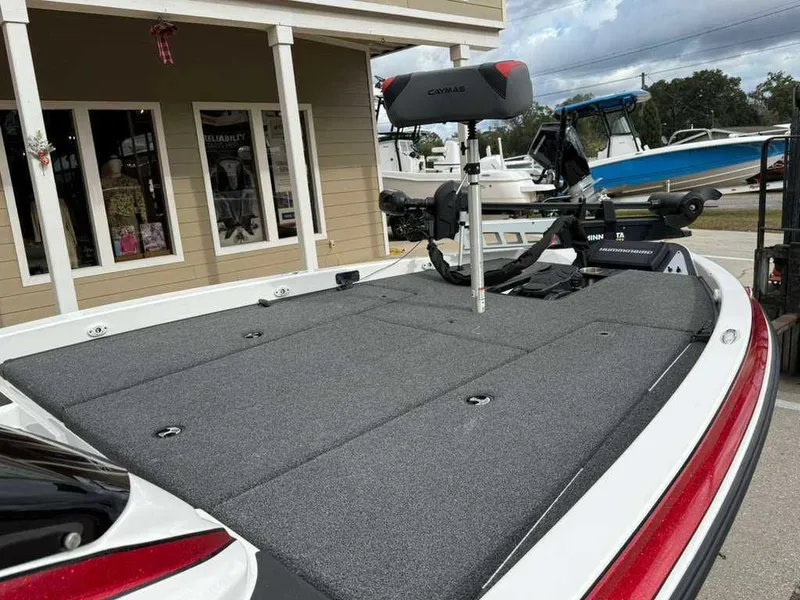 Slide: The Image of 2022 Caymas CX 19 boat with gray deck, in front of a building. - 12