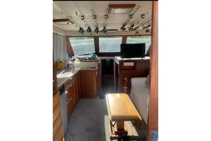 Slide: The Image of Interior of 1985 Hatteras 36 Convertible boat with fishing rods and cozy seating. - 5