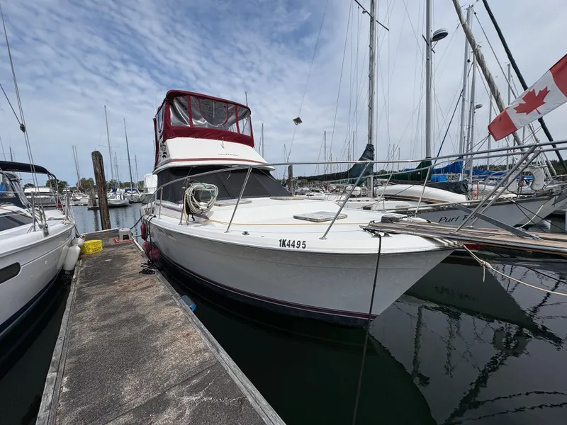 Slide: The Image of 1986 Trojan 32 Sedan boat docked at marina with Canadian flag. - 10