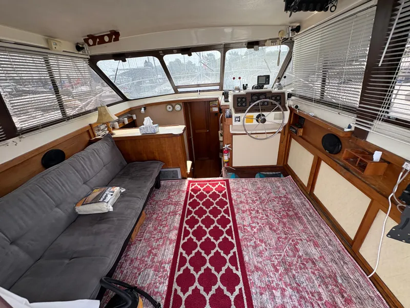 Slide: The Image of 1986 Trojan 32 Sedan interior with sofa, steering wheel, and red patterned rug. - 11