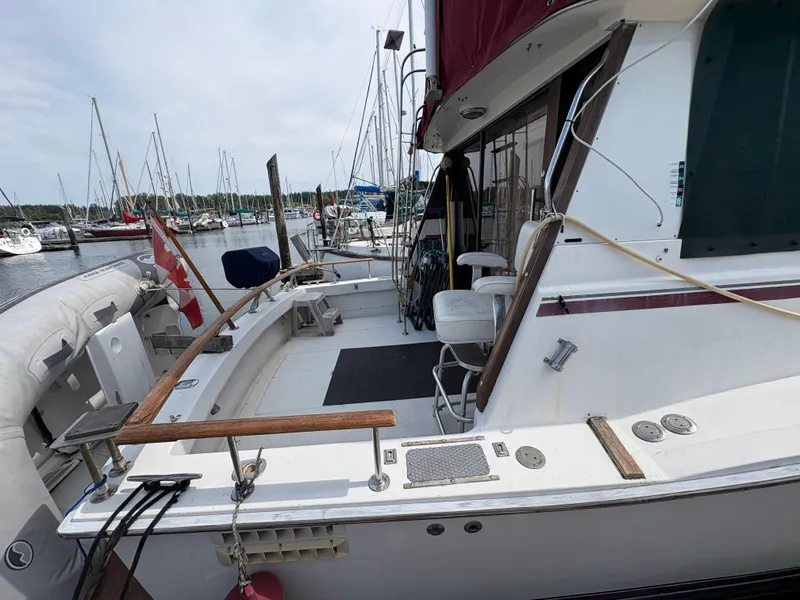 Slide: The Image of 1986 Trojan 32 Sedan yacht docked at marina with Canadian flag. - 17