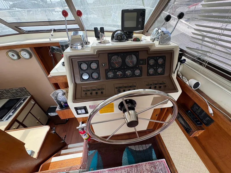 Slide: The Image of 1986 Trojan 32 Sedan helm with gauges, steering wheel, and navigation equipment. - 28