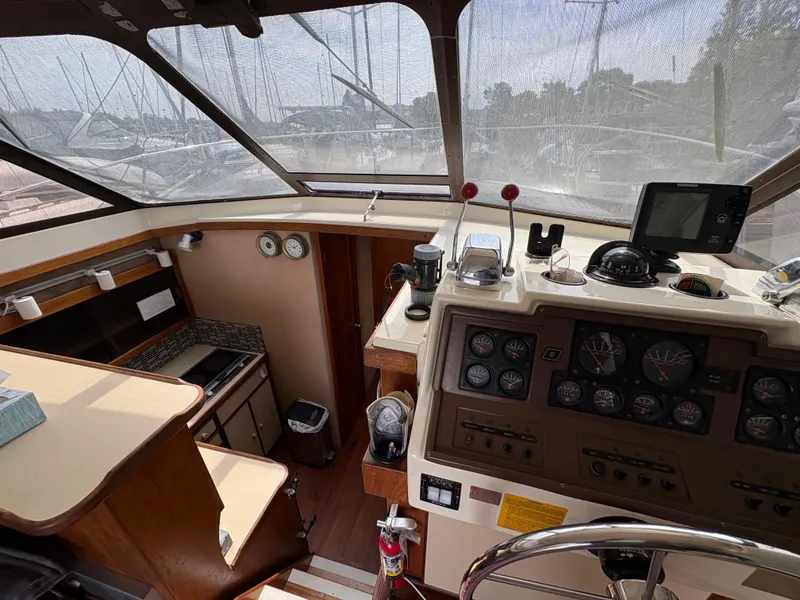 Slide: The Image of 1986 Trojan 32 Sedan interior with helm, gauges, and kitchen area. - 30