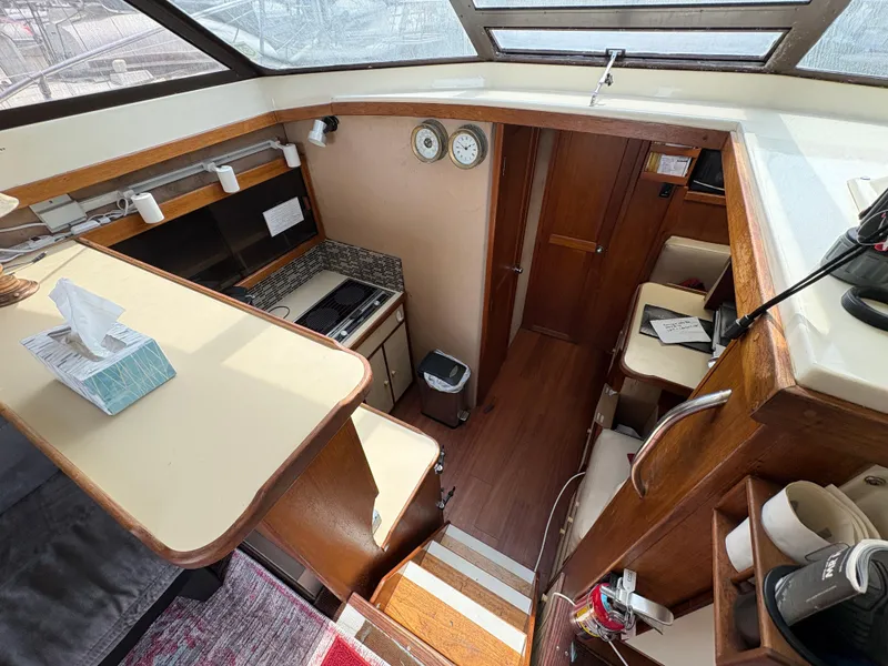 Slide: The Image of Interior of a 1986 Trojan 32 Sedan boat with wood accents and compact kitchen area. - 31