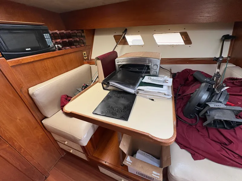 Slide: The Image of 1986 Trojan 32 Sedan interior with table, microwave, and seating area. - 32