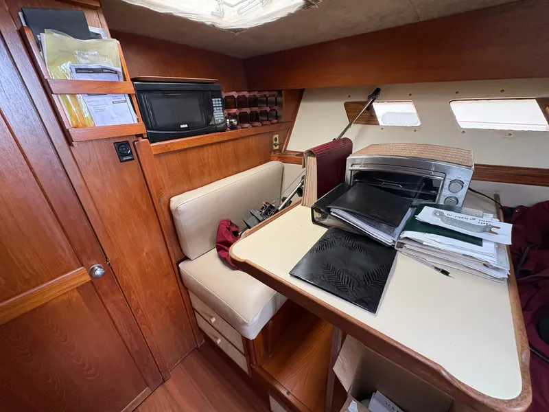 Slide: The Image of Interior of a 1986 Trojan 32 Sedan boat with a cozy seating area and kitchenette. - 34