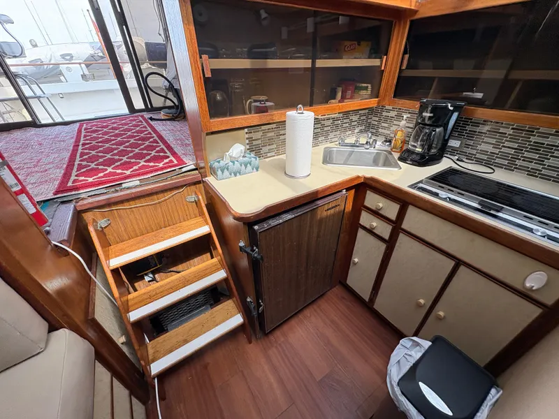 Slide: The Image of 1986 Trojan 32 Sedan boat kitchen with sink, stove, and storage cabinets. - 41