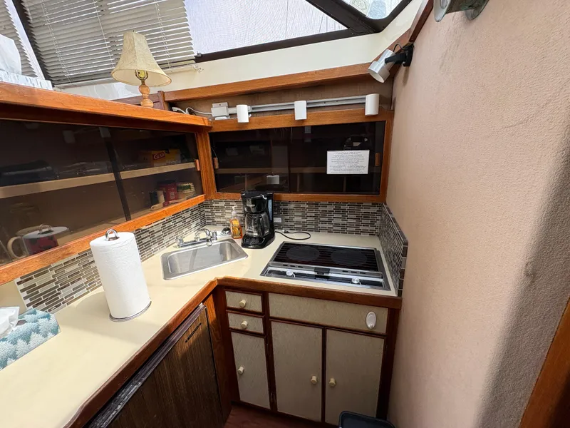 Slide: The Image of 1986 Trojan 32 Sedan kitchen with stove, sink, and coffee maker. - 43