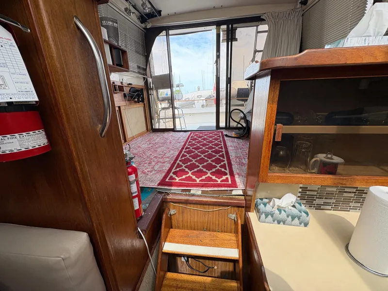 Slide: The Image of Interior of a 1986 Trojan 32 Sedan boat with wooden cabinetry and red carpet. - 48