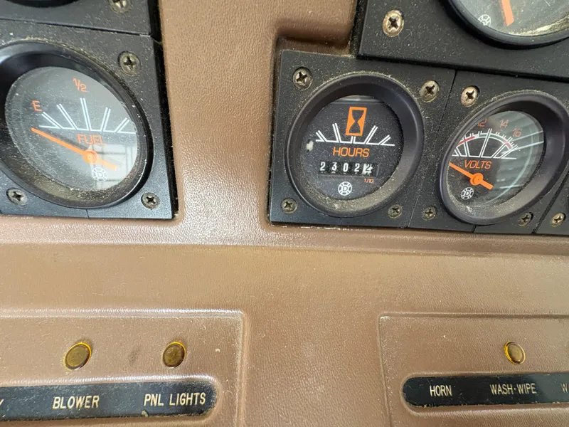 Slide: The Image of Dashboard gauges of a 1986 Trojan 32 Sedan boat, showing fuel, hours, and volts. - 52