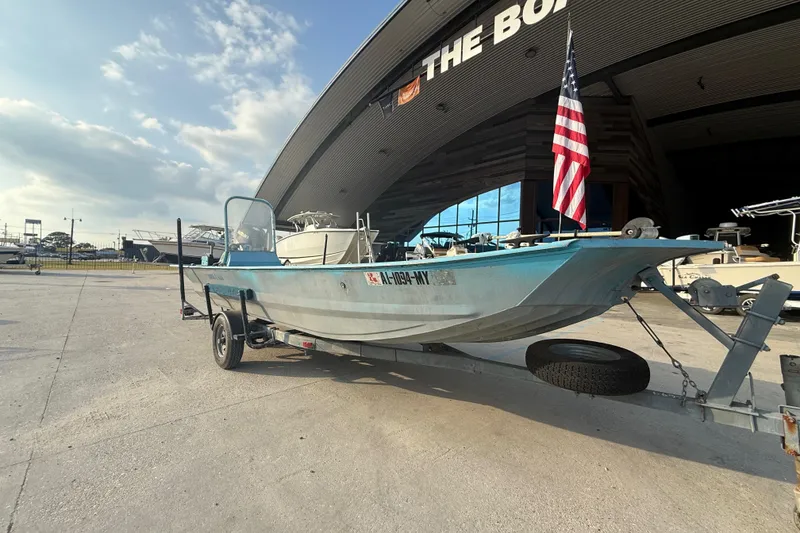 Slide: The Image of 1990 Duracraft 1860 DC boat on trailer, parked outside a large boat dealership. - 15