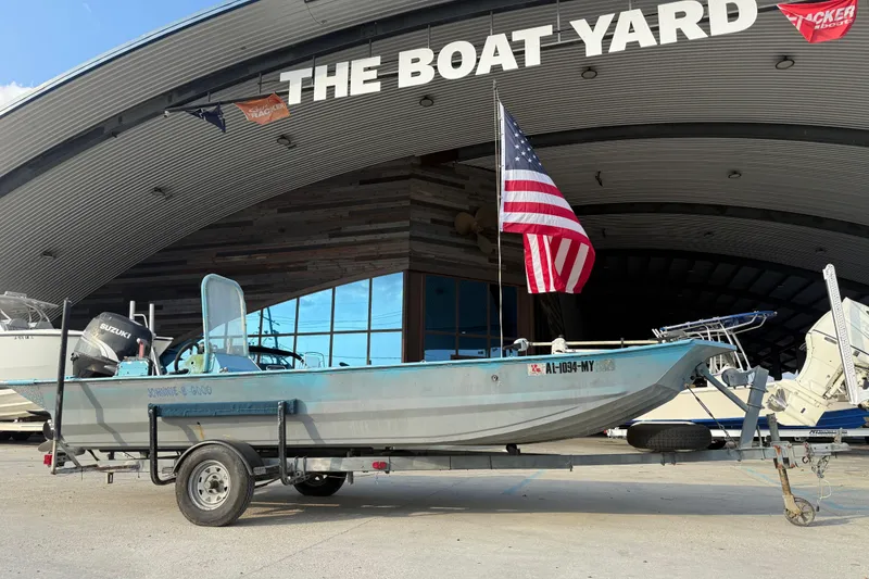 Slide: The Image of 1990 Duracraft 1860 DC boat on trailer at The Boat Yard, American flag displayed. - 9
