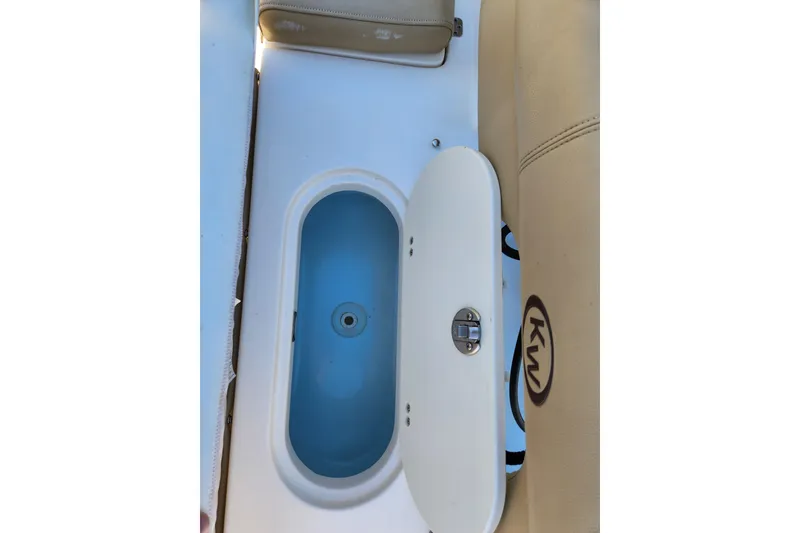 Slide: The Image of 2020 Key West 203 FS boat interior with open storage compartment and beige seating. - 17