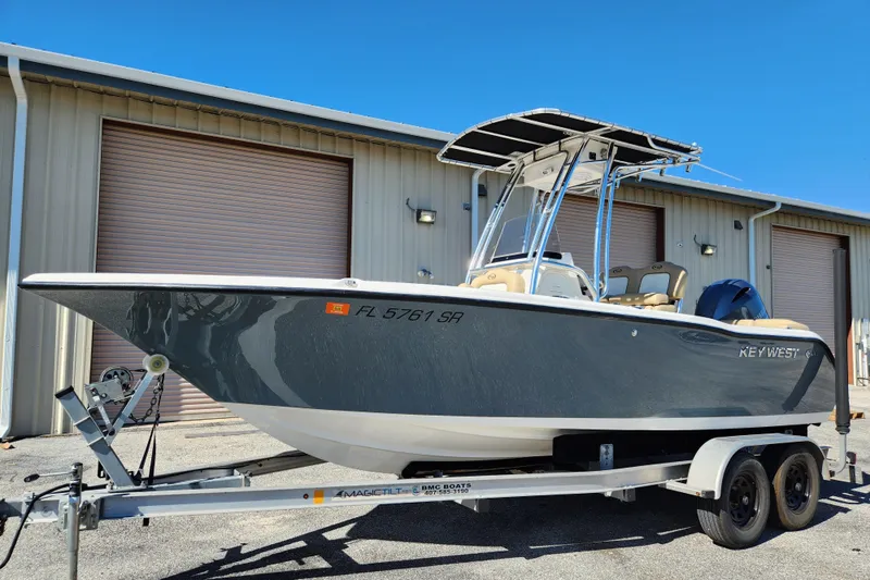 Slide: The Image of 2020 Key West 203 FS boat on trailer, parked outside a warehouse. - 2