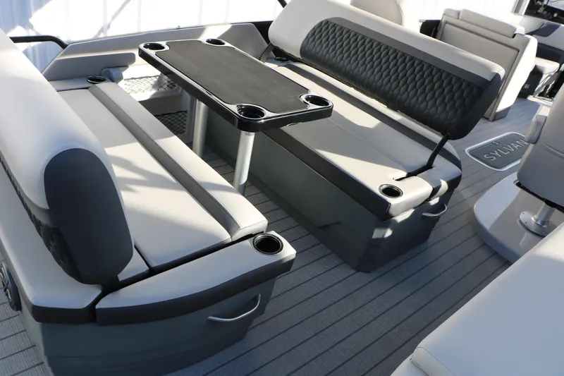 Slide: The Image of 2026 Sylvan L3 DLZ boat interior with cushioned seating and table. - 13