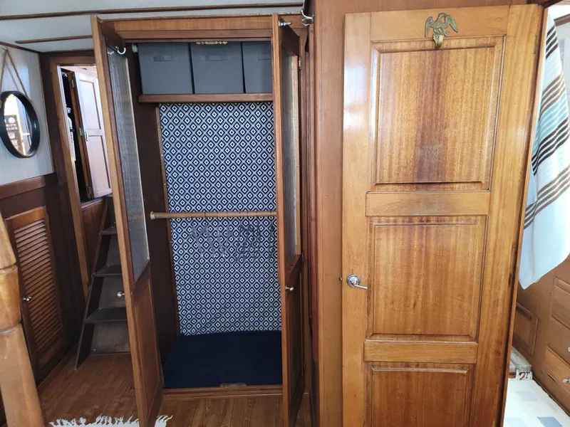 Slide: The Image of Wooden interior of a 1974 Californian 42 LRC boat with open closet and patterned wallpaper. - 14