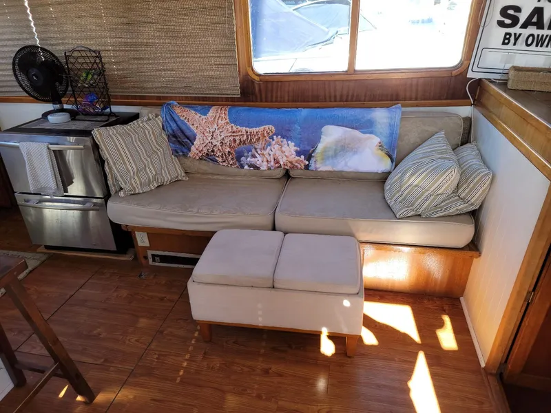 Slide: The Image of Cozy interior of a 1974 Californian 42 LRC with sofa, cushions, and ocean-themed decor. - 2
