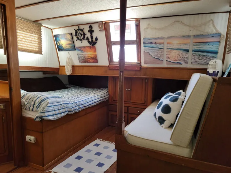 Slide: The Image of 1974 Californian 42 LRC boat cabin with cozy bed, nautical decor, and ocean-themed artwork. - 7