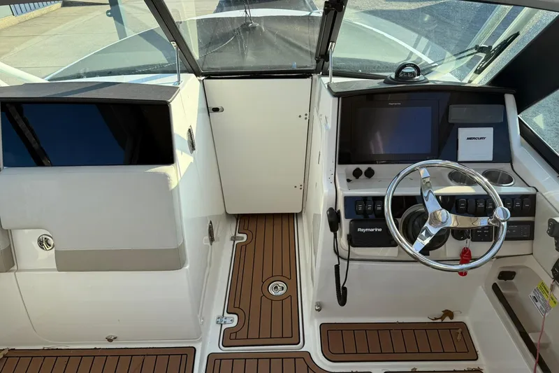 Slide: The Image of 2022 Boston Whaler 240 Vantage boat cockpit with steering wheel and control panel. - 11