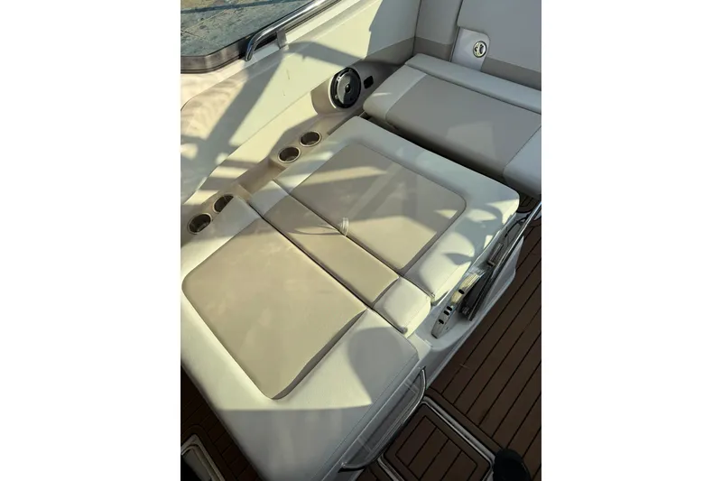 Slide: The Image of 2022 Boston Whaler 240 Vantage boat interior with cushioned seating and cup holders. - 13